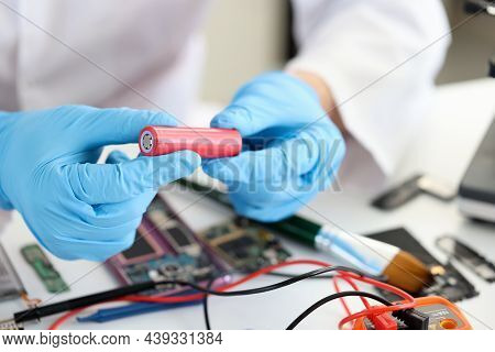 Master Holding Electronic Battery Near Microchips In Workshop Closeup. Replacement Of Batteries In M