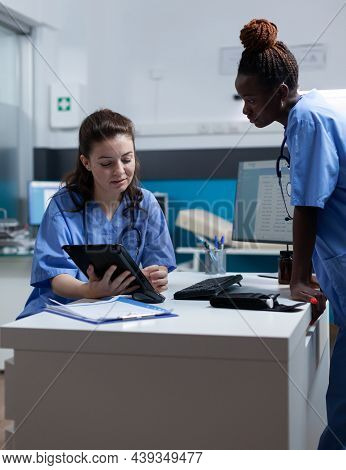 Medical Nurse Team In Uniform Working At Disease Diagonisis Discussinng Symptoms In Hospital Office 