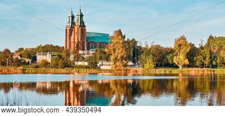 Cathedral In Gniezno Town, Poland, On A Bright Day In Summer With Reflection