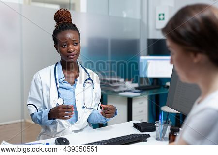 African American Therapist Doctor Discussing With Patient Monitoring Disease Symptoms During Medical