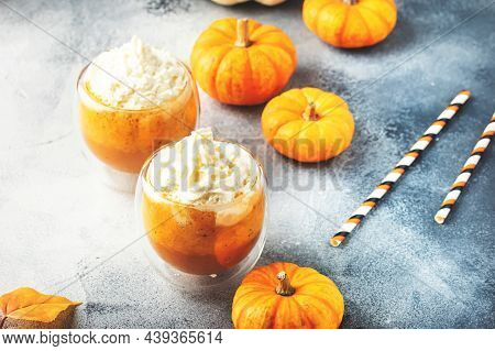 Pumpkin Latte Coffee With Wipper Cream In Glass Cups On Gray Table. Autumn Or Winter Hot Drink In Fe
