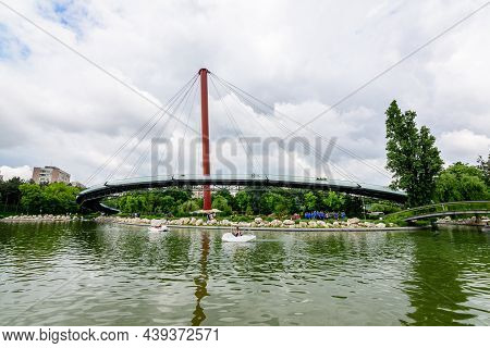 Bucharest, Romania - 29 May 2021: Landscape With The Modern Metallic Bridge, Lake And Green Trees In