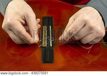 Replacement And Insertion Of Nylon Strings In A Classical Guitar. Lesson For A Musician