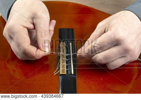 Replacement And Insertion Of Nylon Strings In A Classical Guitar. Lesson For A Musician