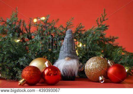 Lovely Little Gnome In Gray Clothes Brought Christmas Balls To Decorate The Christmas Tree, Lights A