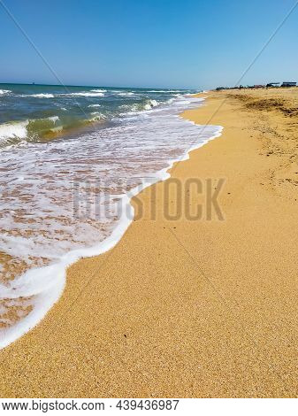 Beautiful Sea At Noon In Summer, Clear Water, Sand Beach. Silent Waves Are Illuminated By The Midday