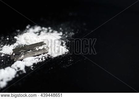 Razor Blade On Drug Powder On Reflection Black Background.copy Space.