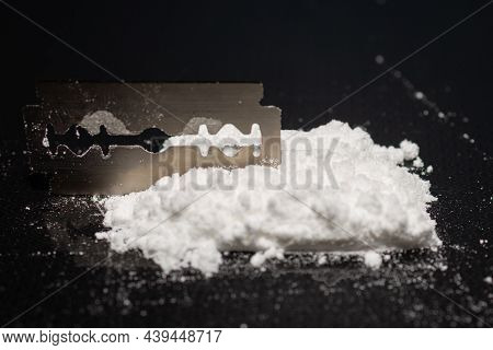 Razor Blade On Drug Powder On Reflection Black Background.copy Space.