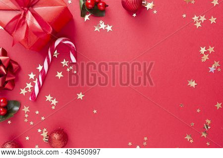 Christmas Background, Red Gift Box On Red Background And Golden Sparkling Conffeti, Candy Canes