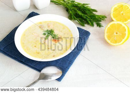 Salmon And Cream Fish Soup In A White Bowl On A Blue Napkin With A Bunch Of Dill And Lemon Halves. L