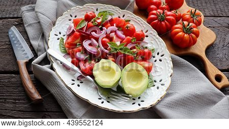 Fresh Healthy Avacado And Tomato Salad With Onions On Dark Rusric Background
