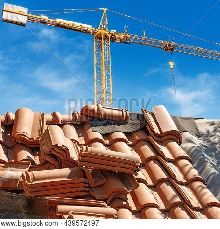 Orange Crane And A Closeup Of A Roof Under Repair With Terracotta Orange Tiles (pantiles, Coppo In I