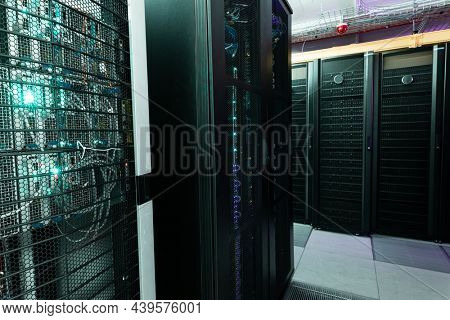 Data center with multiple rows of fully operational server racks. modern cloud computing technology concept.