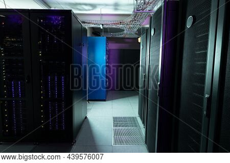 Data center with multiple rows of fully operational server racks. modern cloud computing technology concept.