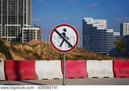 Photo Of A Round White-red Road Sign With A Crossed Out Man On The Background Of A Construction Of M
