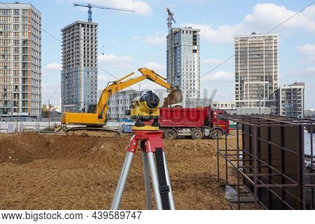 Photo Of A Level At The Construction Site Of Multi-storey Buildings With A Yellow Excavator And An R