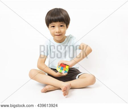Asian Cute Kid Play With Rubic On White Background.