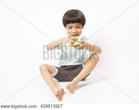 Asian Cute Kid Play With Rubic On White Background.