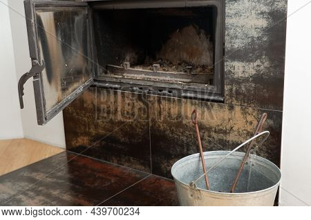 Fireplace Cleaning. Fireplace Cleaning Tools. A Shovel With Ash In A Burnt-out Fireplace.