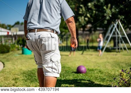 Playing Kickball With Grandpa In The Backyard