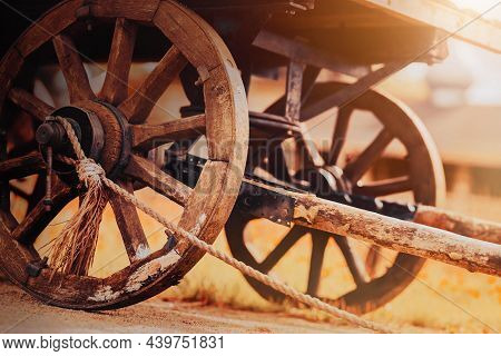 An Old Wooden Cart With Big Wheels Stands On The Road In The Village On An Autumn Sunny Day. Harvest