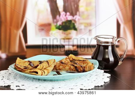 หวาน pancakes บนแผ่นกับนมข้นบนโต๊ะในห้อง