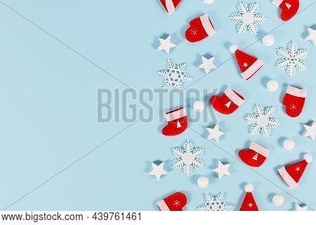 Christmas Flat Lay With Red Santa Hats, Winter Gloves And Socks With Stars And Snowflakes On Blue Ba