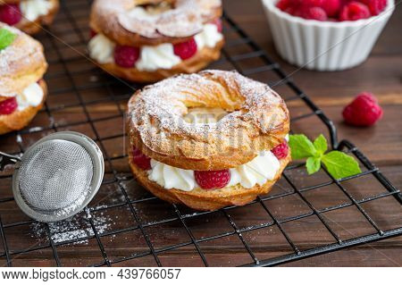 Choux Pastries. Choux Rings With Cream Of Cream Cheese Or Cottage Cheese And Fresh Raspberries, Dust