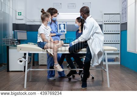 Specialist Therapist Woman Asisstant Analyzing Radiography Discussing Healthcare Treatment With Afri