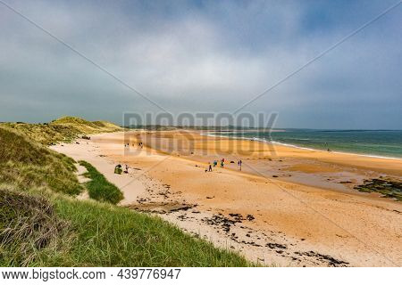 Embleton Bay and Burn with sandy beach with the ruins of Dunstanburgh Castle
