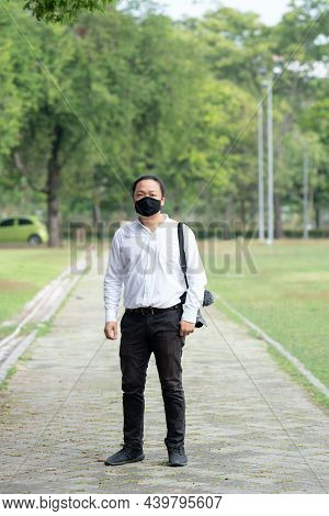 Asian Freelance Long Hair Man With Black Face Mask Is Standing And Posting On The Walk Way In The Ga