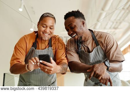 Horizontal Low Angle Shot Of Young African American Man And Woman Working Together In Modern Cafe Wa