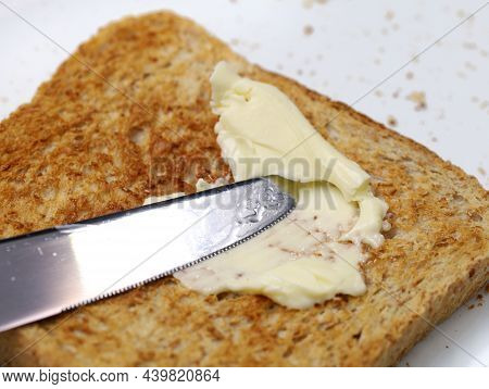 Close Up Of Knife Spreading Magarine Onto Wholemeal Toast