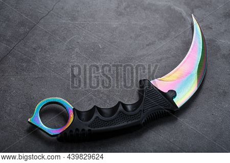 A Dagger With A Steel Blade With A Gradient Color On A Black Background.