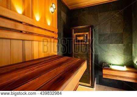 Interior Of Wooden Finnish Sauna With Stove. The Finnish Sauna Is A Substantial Part Of Their Cultur