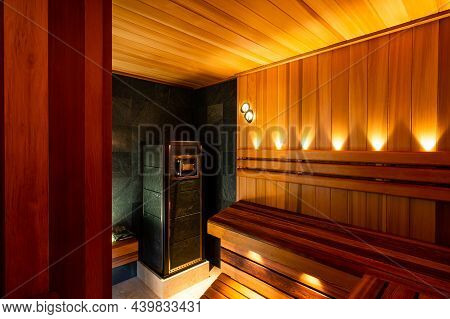 Interior Of Wooden Finnish Sauna With Stove. The Finnish Sauna Is A Substantial Part Of Their Cultur