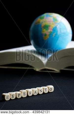 Esperanto Inscription Next To The Globe And Open Book, Dictionary. The Concept Of Creating, Learning