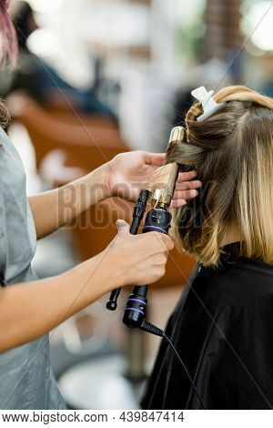 Woman getting her hair curled at a beauty salon