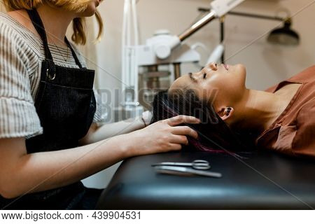 Beautician giving eyebrow treatment to a customer at a beauty salon