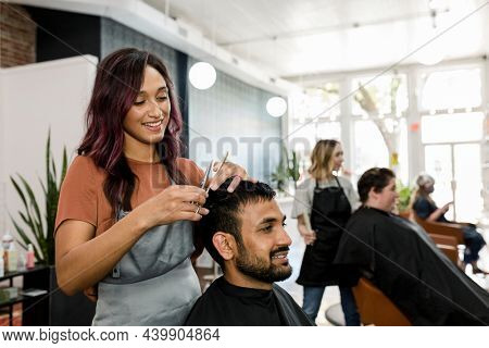 Man getting a haircut from a hair stylist at a barber shop
