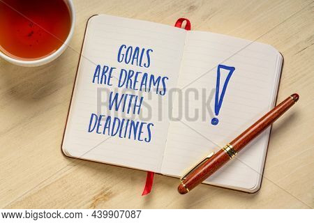 goals are dreams with deadlines - inspirational handwriting in a notebook with a cup of tea, business, education, goal setting and personal development concept