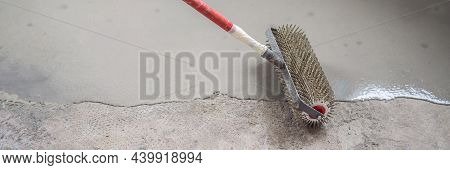 Plasterer During Floor Covering Works With Self-levelling Cement Mortar, Uses A Needle Roller Banner