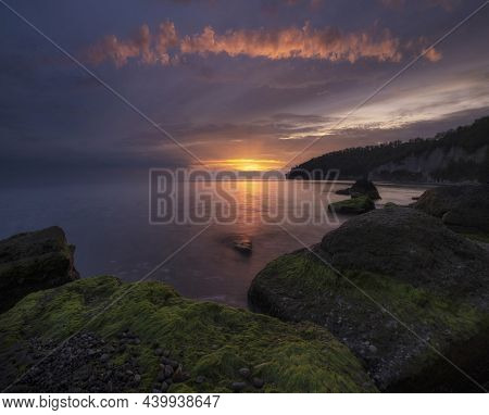 Beautiful Sea In Autumn With Epic Sunset With Green Algae Boulders.