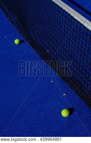 Ball Next To The Net Of A Blue Paddle Tennis Court. Sport Healthy Concept.