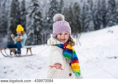 Lovely Child Girl Playing Snowball Fight On A Winter Walk In Snow Nature.