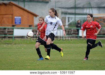 KAPOSVAR, HUNGARY - NOVEMBER 3: Csenge Ujvari (white 8) in action at Hungarian Championship under 15 women soccer game Rakoczi FC (white) vs Pecsi MFC (red) November 3, 2013 in Kaposvar, Hungary.