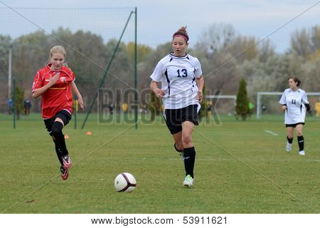 KAPOSVAR, HUNGARY - NOVEMBER 3: Kata Recsei (white 13) in action at Hungarian Championship under 15 women soccer game Rakoczi FC (white) vs Pecsi MFC (red) November 3, 2013 in Kaposvar, Hungary.