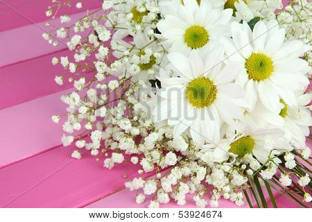Beautiful flowers on wooden background