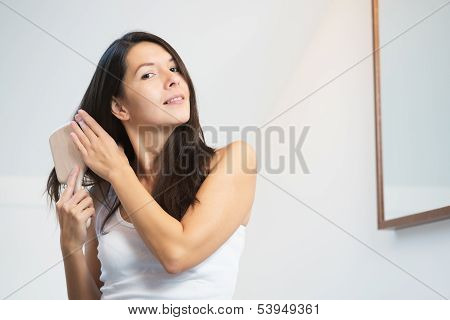 Attractive Young Woman Brushing Her Long Hair