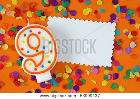 Number nine birthday candle on orange background